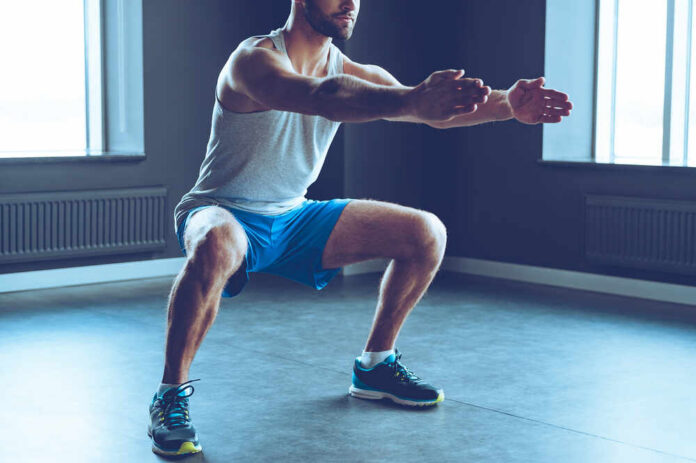 shutterstock_390236356.jpg Man performing a squat exercise in a gym