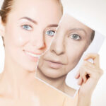 A woman holding a photo showing her younger and older self