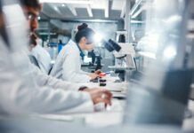 Fat’s Role in Cancer Revealed Scientists working in a laboratory with microscopes and test tubes