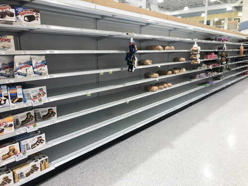 Empty grocery store shelves with a few snack items remaining
