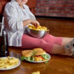 Child sitting on the floor enjoying snacks from a bowl