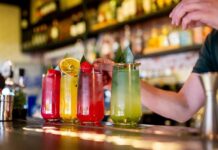 A bartender preparing colorful cocktails at a bar
