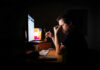 Late Bedtime Linked to Mental Health Risks! A man sitting at a desk with a computer, holding glasses and looking stressed