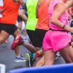 Elite Athletes’ Counterintuitive Training Secret Revealed Runners participating in a marathon, wearing colorful athletic gear