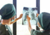 Two medical professionals examining an x-ray of a chest