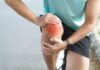 Greens vs. Pills: The Bone Health Battle Athlete holding their knee in pain while exercising outdoors