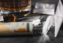 ‘Hollywood Dose’ Trend – FDA Alarm Bells A close-up of a syringe, pills, and a glass of alcohol on a dark surface