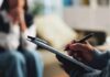 Hidden Health Combo Supercharging your Depression Odds A therapist taking notes during a session with a client in the background