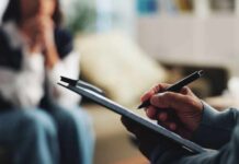The Biological Marker That Flags Hidden Depression Risk A therapist taking notes during a session with a client in the background
