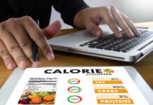 Common Diet Villain Quietly Powers Your Gut Person using a calorie counter app on a tablet while working on a laptop