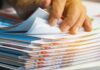 Hand sorting through a stack of colorful documents