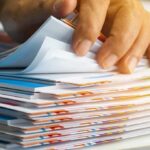 Hand sorting through a stack of colorful documents