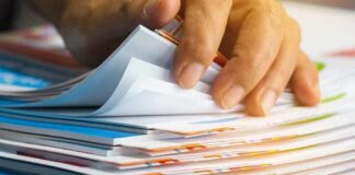 Hand sorting through a stack of colorful documents