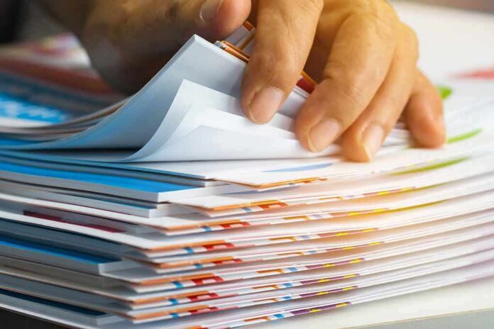 Hand sorting through a stack of colorful documents