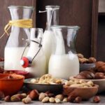 Nuts Slash Death Risk, But There’s a Catch Glass bottles of milk surrounded by assorted nuts in bowls