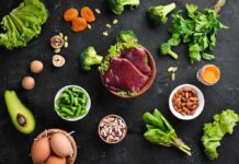 The Four Foods Secretly Making You Smell Bad Raw liver with assorted healthy foods on dark surface