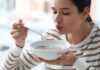 Diet and Depression: Nutrients That Boost Mood Woman blowing on a spoonful of hot soup