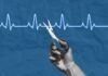 Two-in-One Heart Cure Shocks Cardiology A hand holding scissors above a heartbeat line on a blue background