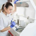 Lab technician using an analyzer with a pipette