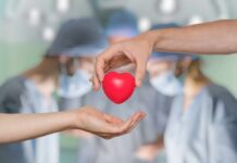 Harvard Doc’s Discovery That Saved Millions Two hands exchanging a red heart symbol in a surgical setting