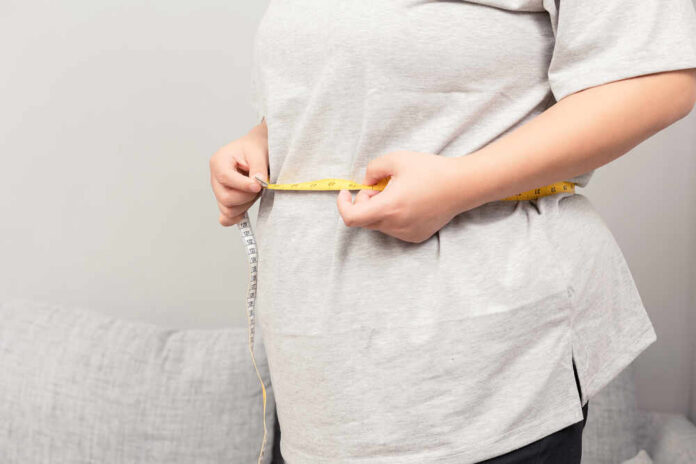 Asian,Fat,Girl,Sitting,On,The,Sofa Person measuring their waist with a tape measure
