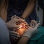 Dental surgeons perform oral procedure with instruments