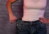 How Weight Swings Influence Cancer Risk person in white tank top showing loose jeans waistband