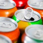 Assorted soda cans with one open pull-tab