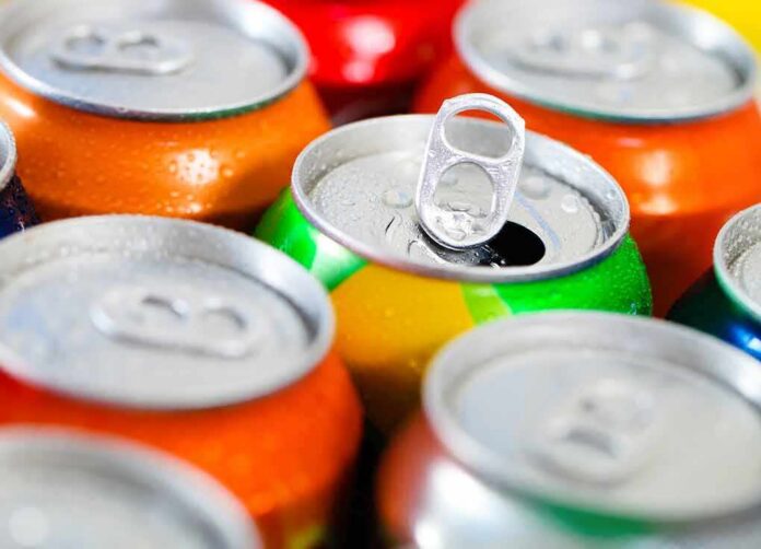Assorted soda cans with one open pull-tab