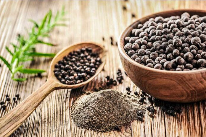 1783890446561-tx55yi-shutterstock-1013574415 Black peppercorns in a wooden bowl and spoon with ground pepper