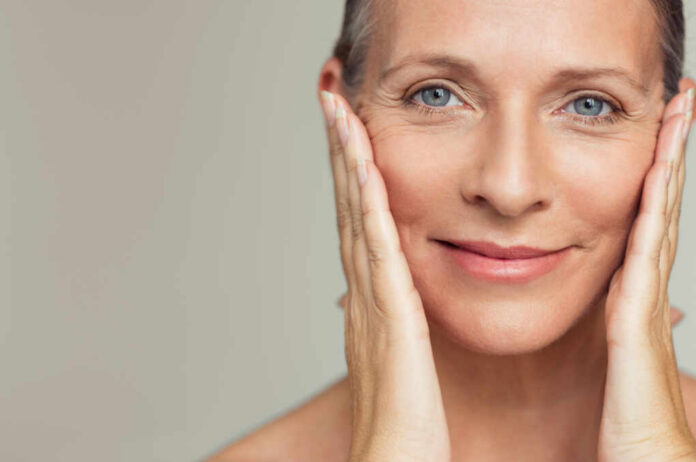Portrait,Of,Beautiful,Senior,Woman,Touching,Her,Perfect,Skin,And Close-up portrait of a smiling woman gently holding her face