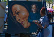 Why Art Should Be Part Of Your Wellness Routine A woman admires a large portrait of a smiling female figure at an outdoor event