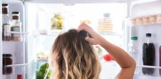 Person looking into an open refrigerator