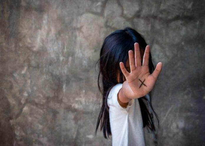 shutterstock_1090916351-1 child with hand raised showing an X on palm