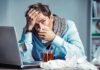Cold That Kills? Doctors Sound Alarm Sick man at desk blowing his nose