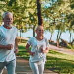 Older couple jogging on a lakeside path
