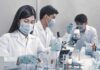 Fruit Sugar Found To Undermine Tumor Defenses in our Bodies Scientists in lab coats working with test tubes and microscopes