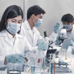 Scientists in lab coats working with test tubes and microscopes