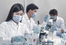 Fruit Sugar Found To Undermine Tumor Defenses in our Bodies Scientists in lab coats working with test tubes and microscopes