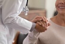 Doctor holding patient’s hand in support