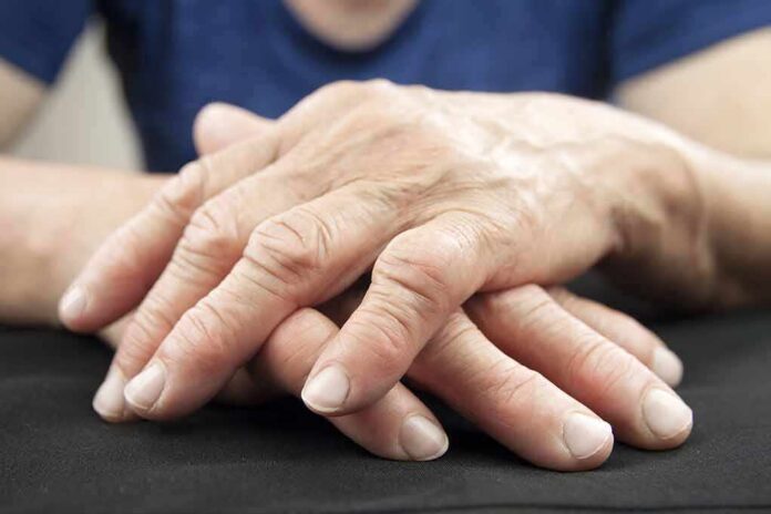 shutterstock_197319983 Elderly hands resting and crossed on a dark surface