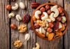 Assorted mixed nuts in a wooden bowl on rustic table