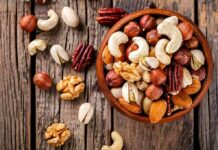 Assorted mixed nuts in a wooden bowl on rustic table