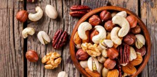 Assorted mixed nuts in a wooden bowl on rustic table