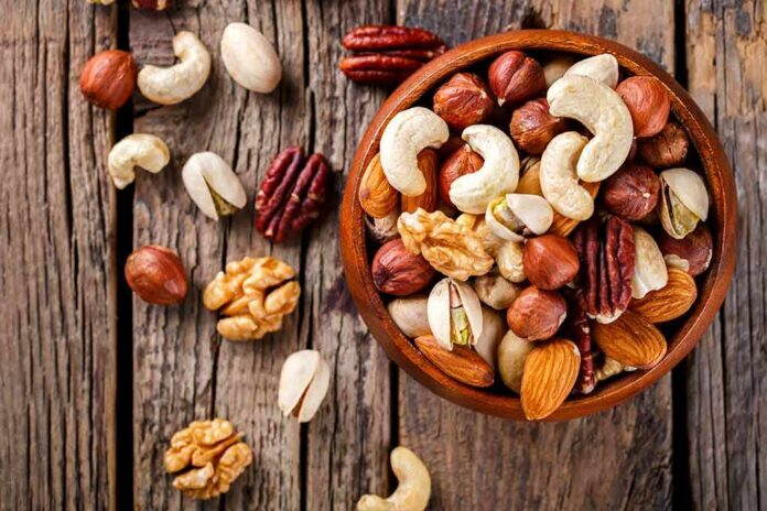 shutterstock_580226476 Assorted mixed nuts in a wooden bowl on rustic table