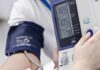 Person having blood pressure measured with digital monitor