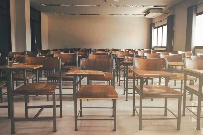 shutterstock_1019829787 Empty classroom with rows of wooden desks and chairs