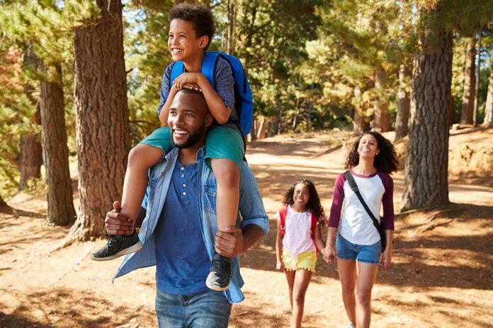 shutterstock_1102115579 family hiking on a forest trail