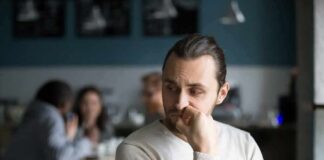 man sitting alone in a cafe looking to the side