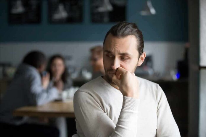 man sitting alone in a cafe looking to the side